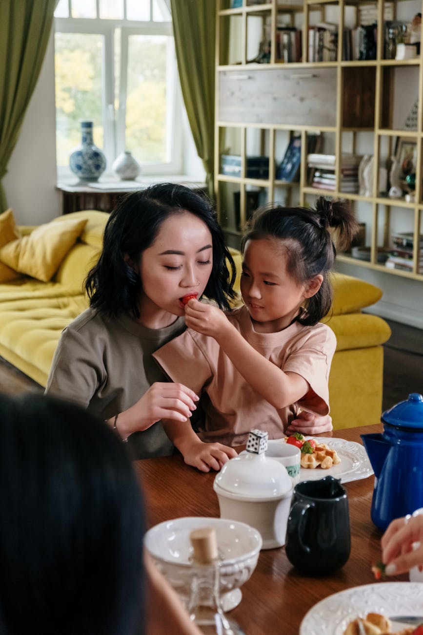 Photo of a Girl Feeding a Woman