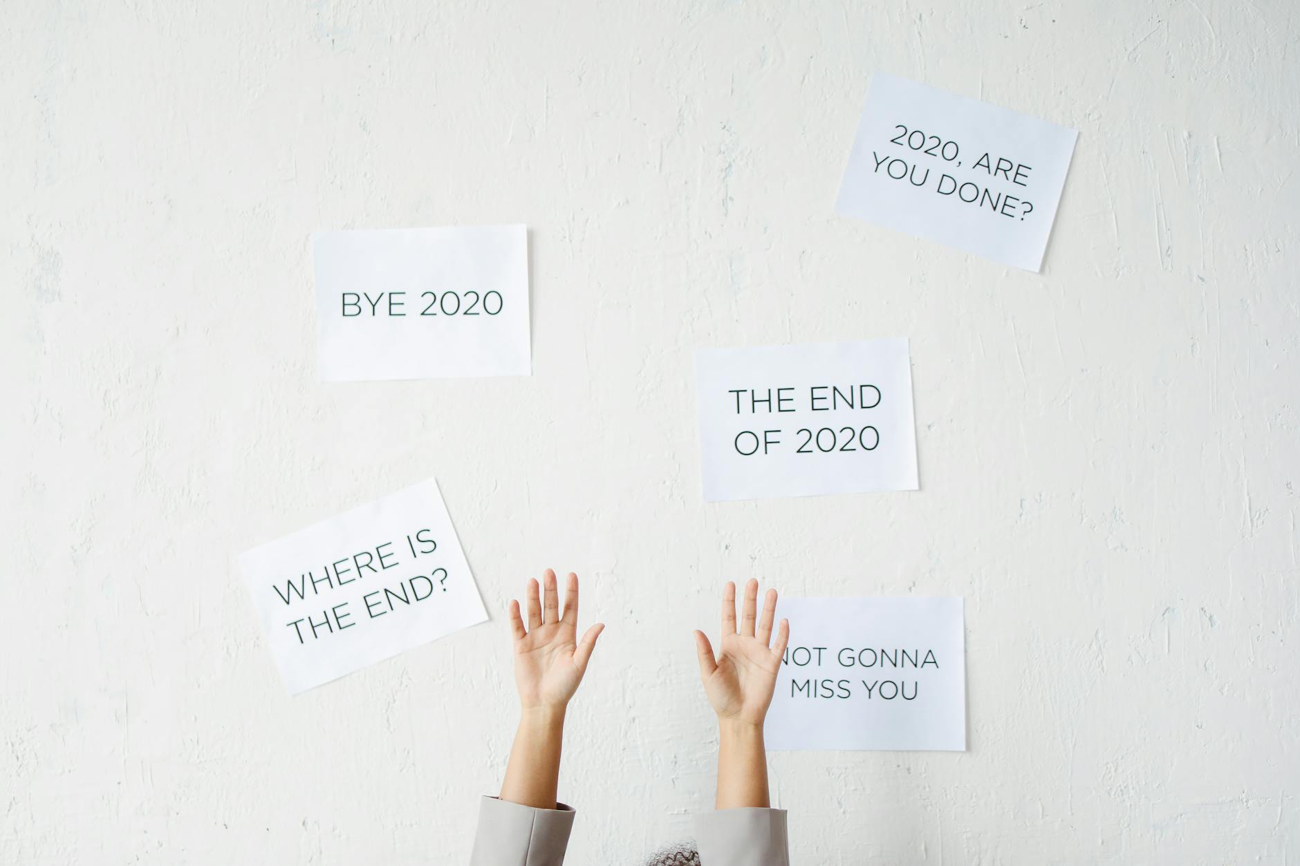 A Person's Hand Raised Up Near a Wall with Posted Signs 