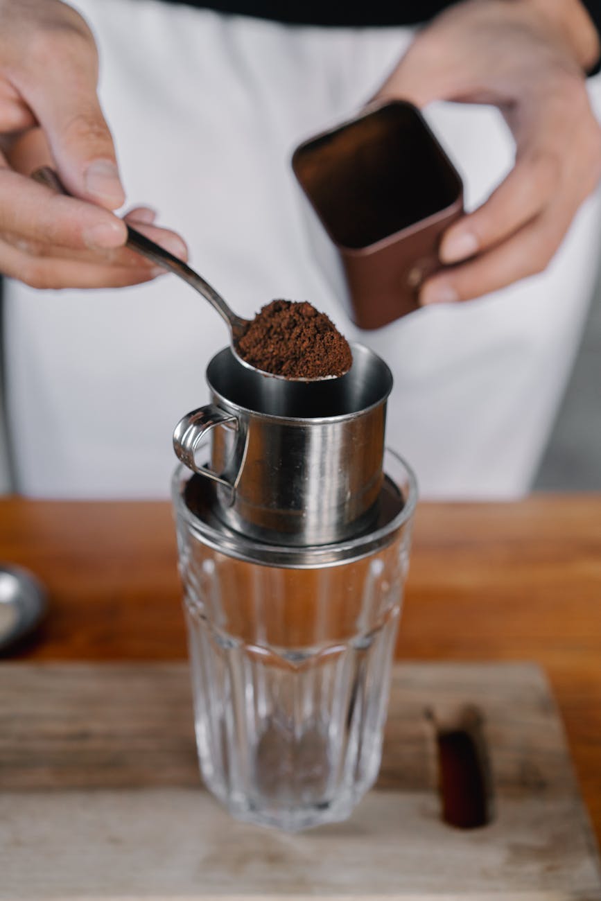 Person Holding Stainless Steel Cup With Brown Powder