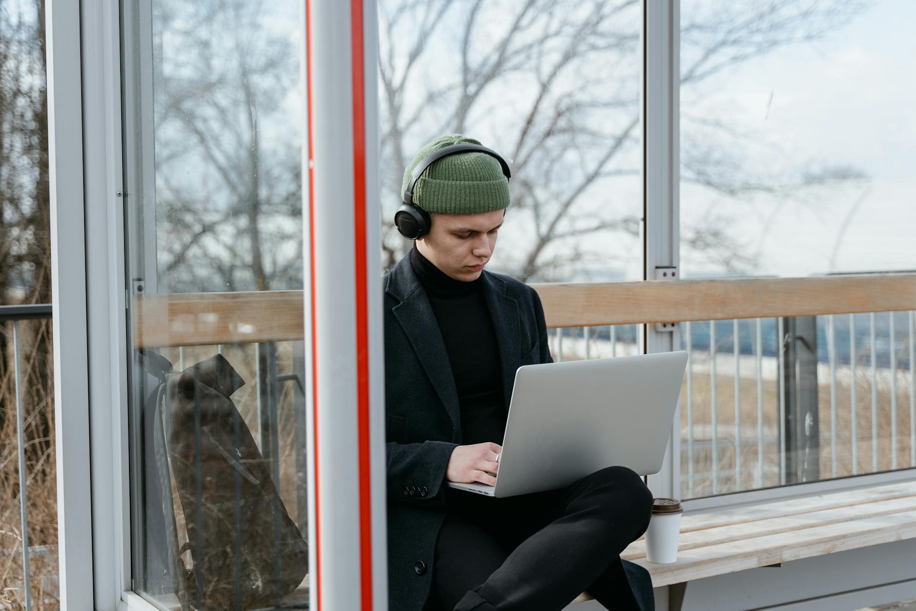 A Man Using a Laptop while Wearing Headphones