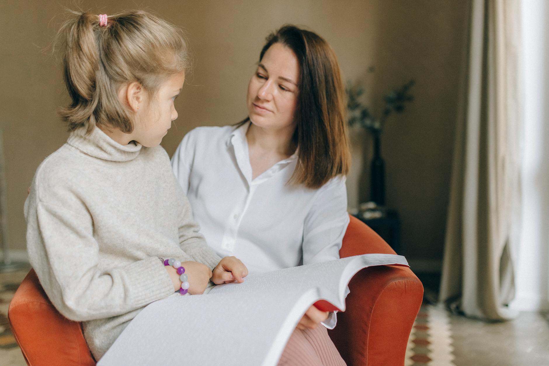 A Woman and Girl Reading a Braille Book